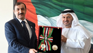 الدكتور قرقاش يسلم الوسام للسفير الجزائري