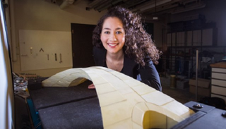 أحد أعضاء الفريق البحثي مع النموذج الذي تم تنفيذه