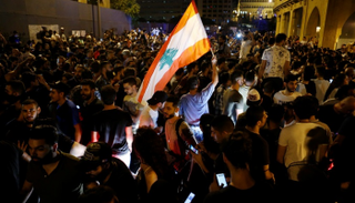 متظاهر يحمل العلم اللبناني خلال احتجاج في بيروت- رويترز