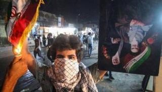 متظاهر عراقي يحرق العلم الإيراني