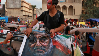 العراقيون يضربون رموز إيران بالأحذية تعبيرا عن الغضب من تغلغل نفوذها