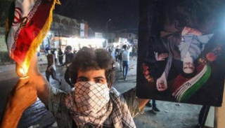 متظاهر عراقي يحرق العلم الإيراني - أرشيفية