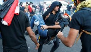 متظاهرون عراقيون يحاولون إسعاف أصدقائهم في الميدان