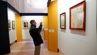  زائر يلتقط صورة للوحة فنية في معرض بالفاتيكان