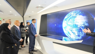 الدكتور ثاني بن أحمد الزيودي يستمع إلى شرح حول الذكاء الاصطناعي