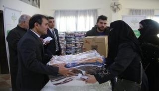أثناء توزيع مسؤولي سفارة الإمارات المساعدات على اللاجئين السوريين
