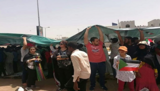 أقباط السودان يغطون رؤوس المعتصمين من أشعة الشمس الحارقة أثناء الصلاة