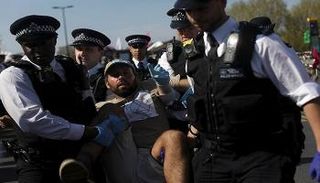 الشرطة البريطانية أثناء اعتقالها أحد المحتجين.