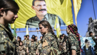 مجندات كرديات وفي الخلفية أوجلان