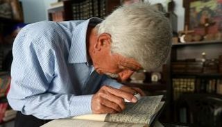 جورج زعرور يعاين إحدى المخطوطات الآرامية