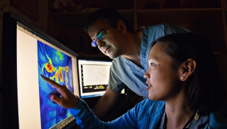 باحثان يشاهدان الأوعية الدموية بعد حقن مريض بالصبغة 