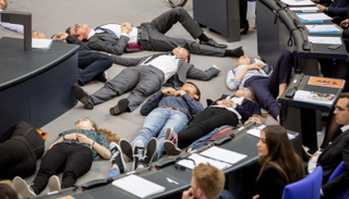 الشباب افترشوا الأرض أمام المنصة في محاكاة لمجموعة جثث على الأرض