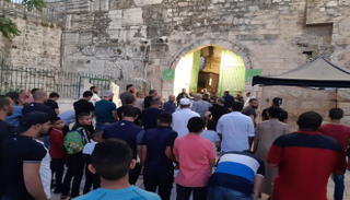 مصلون يؤدون صلاة المغرب عند باب الأسباط بعد منعهم من الدخول للأقصى