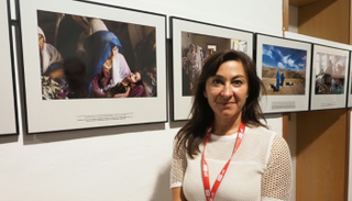 الصحفية لينزي أداريو أمام صورها في مهرجان "فيزا بورليماج"