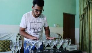 الطالب العراقي سجاد محمود أمام كؤوسه الزجاجية