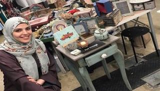 آية عبد الغني تجلس بجانب أعمالها