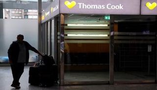 سائح يقف بجوار مكتب توماس كوك في مطار فرانكفورت