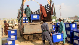 موظفون أفغان ينقلون صناديق الاقتراع