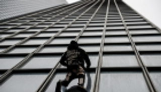 رجل العنكبوت يتسلق ناطحة سحاب تضامنا مع العمال