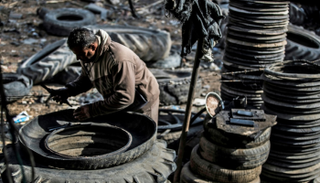 عامل في ورشة لإعادة تدوير الإطارات