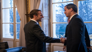 الرئيس الفرنسي إيمانويل ماكرون خلال مصافحته خوان جوايدو في باريس