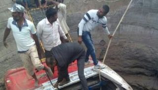 عمال إغاثة حول حافلة سقطت في بئر بالهند