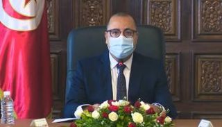 رئيس الوزراء التونسي مرتديا الكمامة