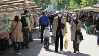 مارة يرتدون كمامات للوقاية من فيروس كورونا في باريس