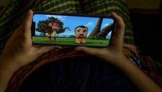 طفل يشاهد مسلسل مايتي ليتل بيم على شاشة هاتف محمول في منزله بنيودلهي 