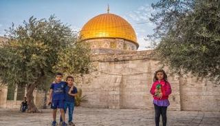 أطفال فلسطينيون وفي الخلفية قبة الصخرة
