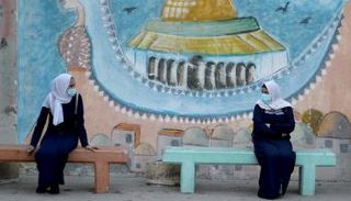 طالبتان ترتديان كمامتين وتحرصان على التباعد في غزة