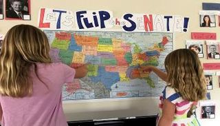 أطفال يستخدمون خريطة وصور المرشحين لمعرفة النتائج