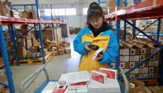 موظفة تكشف على المنتجات قبل تسليمها إلى الزبائن في 