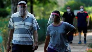 أشخاص يضعون كمامات خلال سيرهم في الشارع