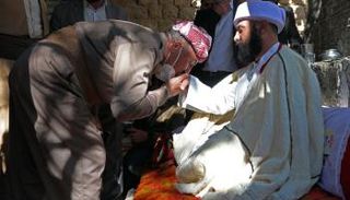 أحد الأيزيديين يقبل يد علي إلياس