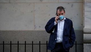 متداول يتحدث على هاتفه خارج بورصة نيويورك - رويترز