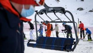  متزلجون يضعون الكمامات يتهيأون للصعود إلى مقصورة التلفريك بسويسرا 