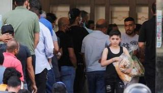 أشخاص يصطفون في طابور لشراء الخبز في مخبز ببيروت