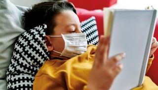 طفل يرتدي الكمامة في المنزل