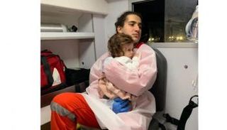 المسعف يحمل الطفلة