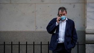 متداول يتحدث على هاتفه خارج بورصة نيويورك - رويترز