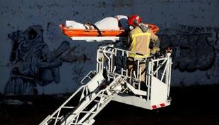 قوات الإنقاذ تنقل إحدى ضحايا الحريق