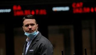 متداول يمر عبر عرض أسعار الأسهم الرقمية خارج بورصة نيويورك – رويترز