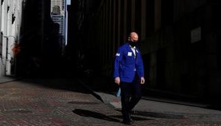 متداول يرتدي قناعًا خارج بورصة نيويورك - رويترز