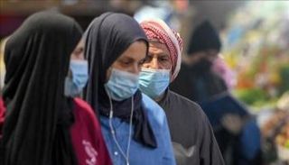 أشخاص يرتدون كمامات للوقاية من كورونا بفلسطين