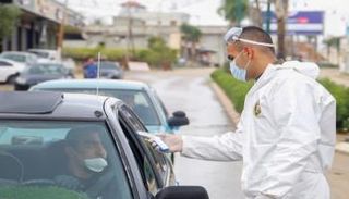 شخص يخضع لفحص درجة الحرارة بفلسطين