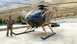 الطيار الأفغاني نعيم أسدي بجوار مروحيته