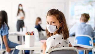 طفلة تضع الكمامة داخل الفصل المدرسي