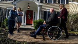 كايتي ماركو (إلى اليمين) في منزل أهلها مع زوجها على الكرسي المتحرك