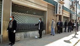 موظف بأحد مصارف ليبيا يحصي أوراقًا من فئة الـ20 دينارًا. (أرشيفية)ليبيا